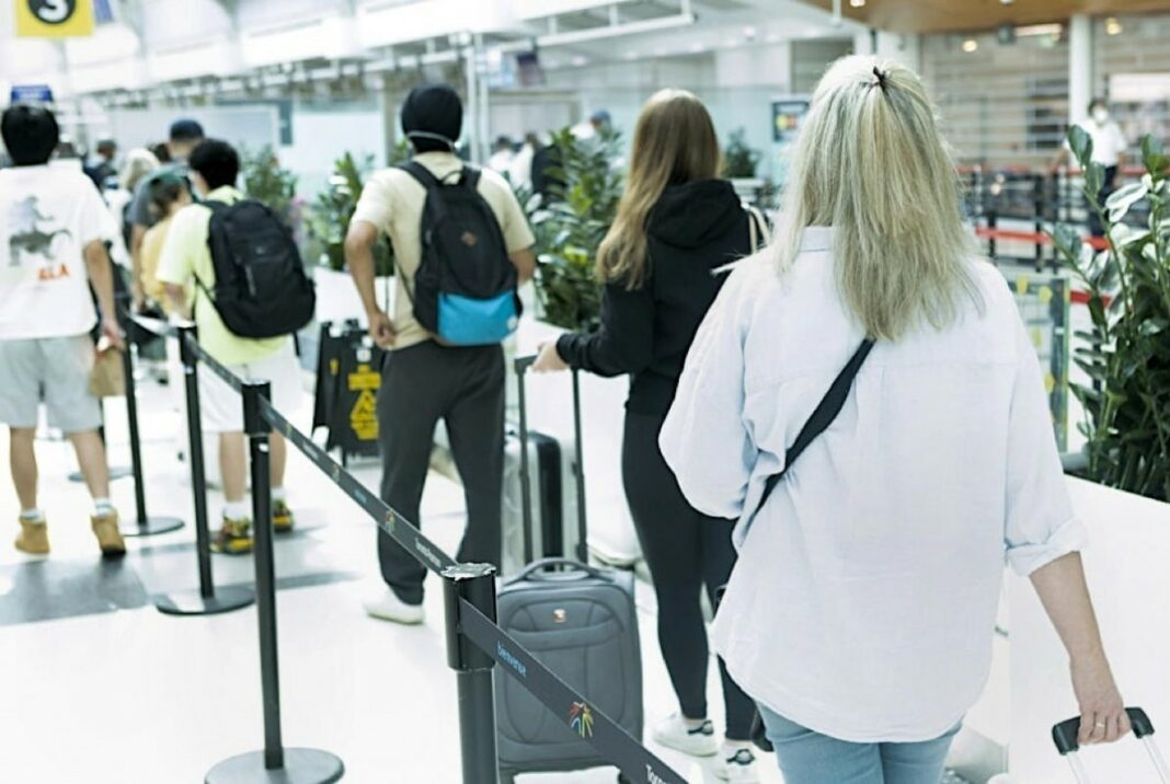 Voyageurs faisant la queue à l'aéroport pour l'enregistrement.