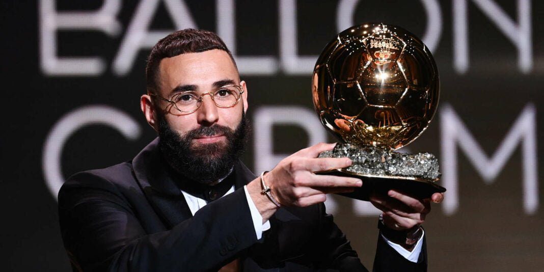 Karim Benzema en lice pour le prestigieux titre de Joueur de l’année aux Globe Soccer Awards aux côtés de Kylian Mbappé Karim Benzema tenant le Ballon d'Or lors d'une cérémonie.