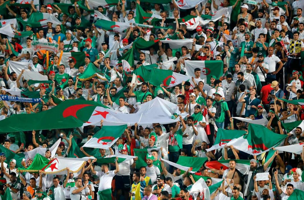 Foule de supporters algériens avec drapeaux lors d'un match.