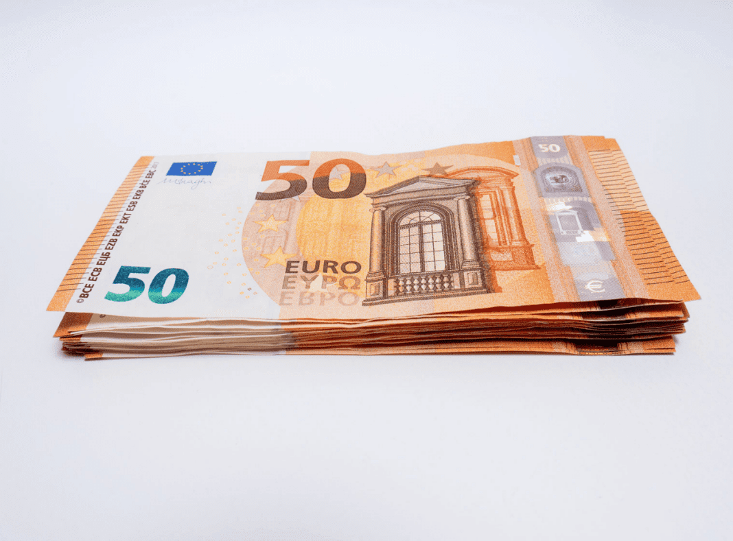 Billets de 50 euros empilés sur fond blanc.