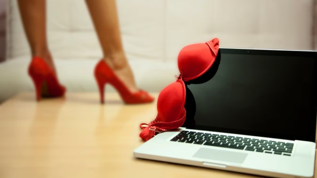 Drame à Oued Zem- sextorsion : L’Effroyable toile de chantage sexuel qui Piège des Israéliens, une femme enceinte en garde à vue Femme en talons rouges près d'un ordinateur portable et d'un soutien-gorge rouge.