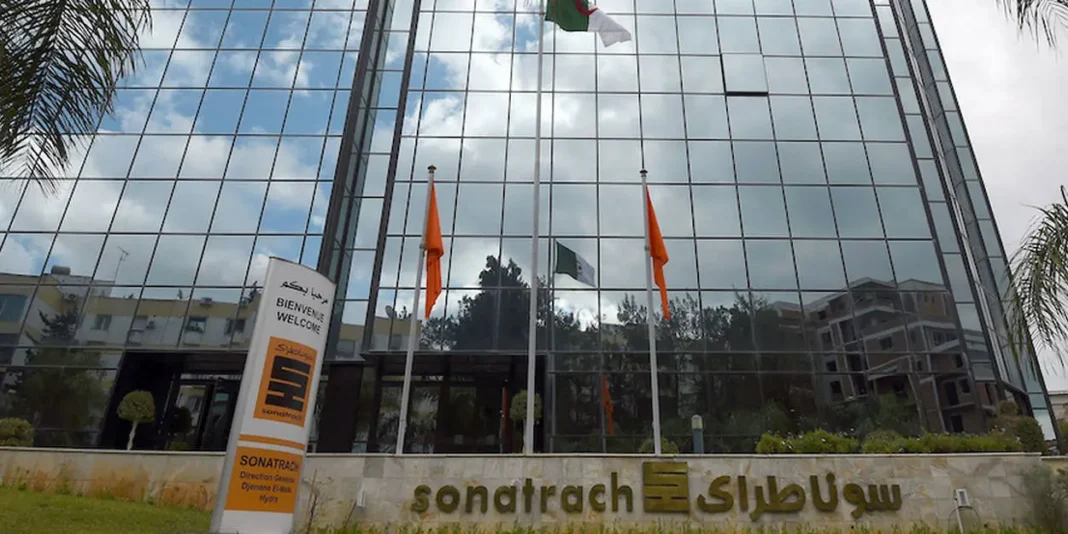 Sonatrach : découvrez les ambitions du géant gazier pour les 4 ans à venir Façade en verre du siège de Sonatrach avec drapeaux algériens.