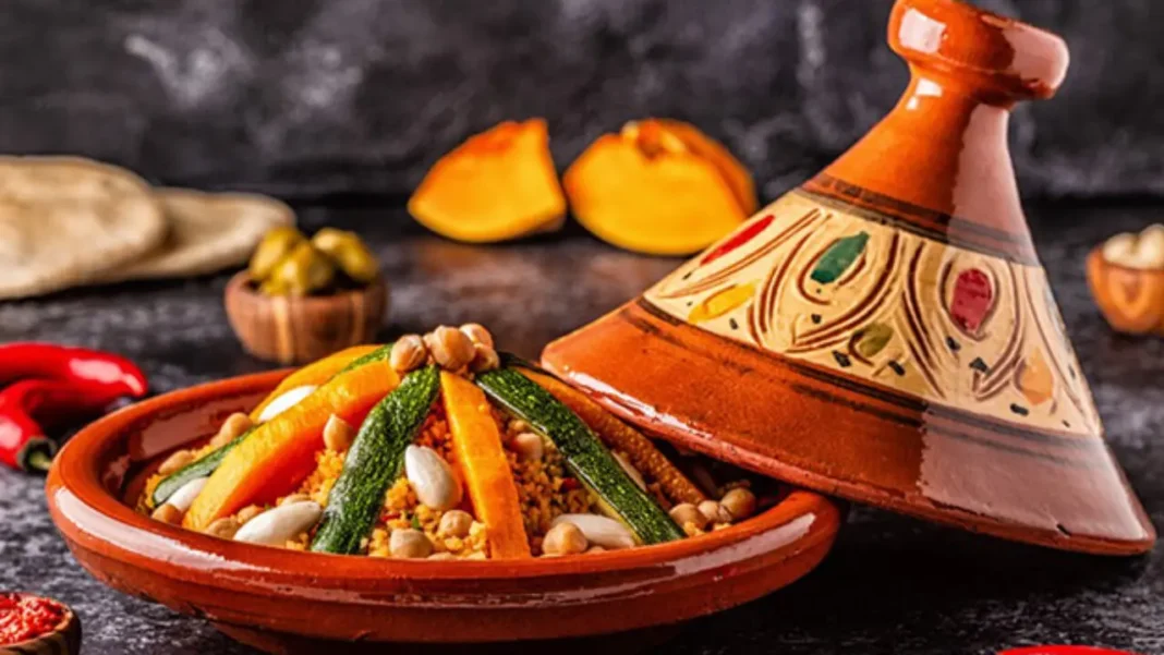 Plat de légumes et de céréales avec tagine en arrière-plan.