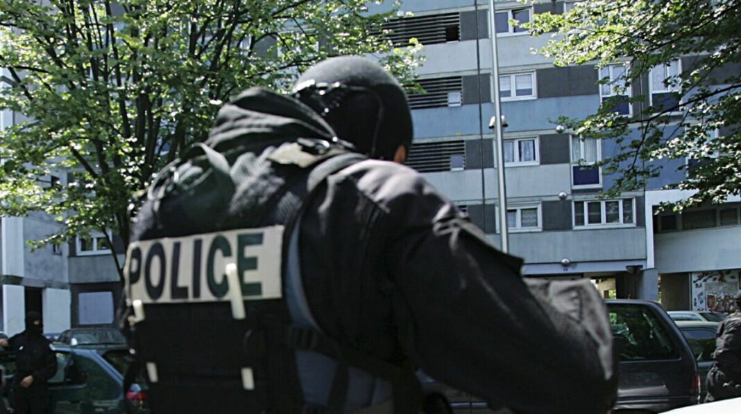 Tragédie familiale à Drancy : une mère de famille Kabyle victime d’un acte impensable Policier en uniforme avec le mot 'POLICE' visible dans un quartier résidentiel.