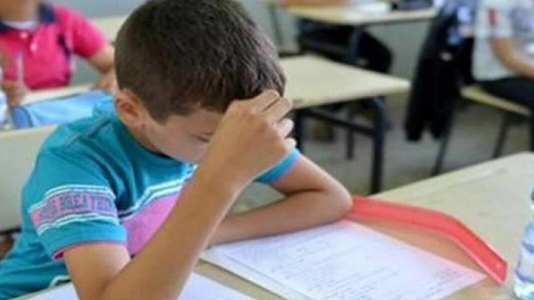 Anticiper les examens du premier trimestre en Algérie : Découvrez à quoi s’attendre dans les questions ! Jeune garçon concentré en train de réviser pour un examen en classe.