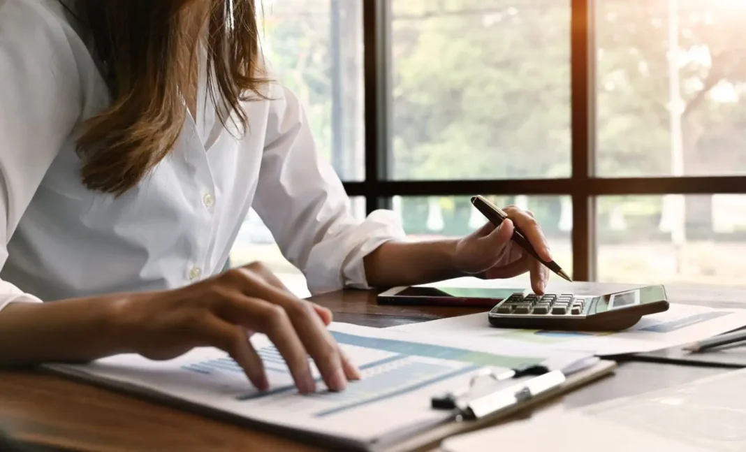Vous voulez mieux gérer vos finances? Lisez ces précieux conseils Femme utilisant une calculatrice et un smartphone pour gérer ses finances.