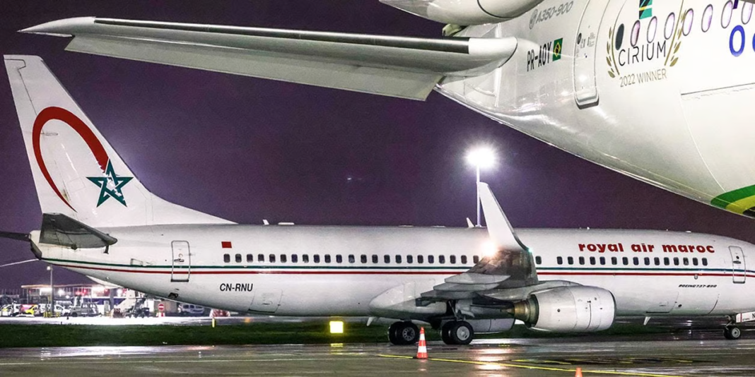 Avion Royal Air Maroc stationné à l'aéroport la nuit.