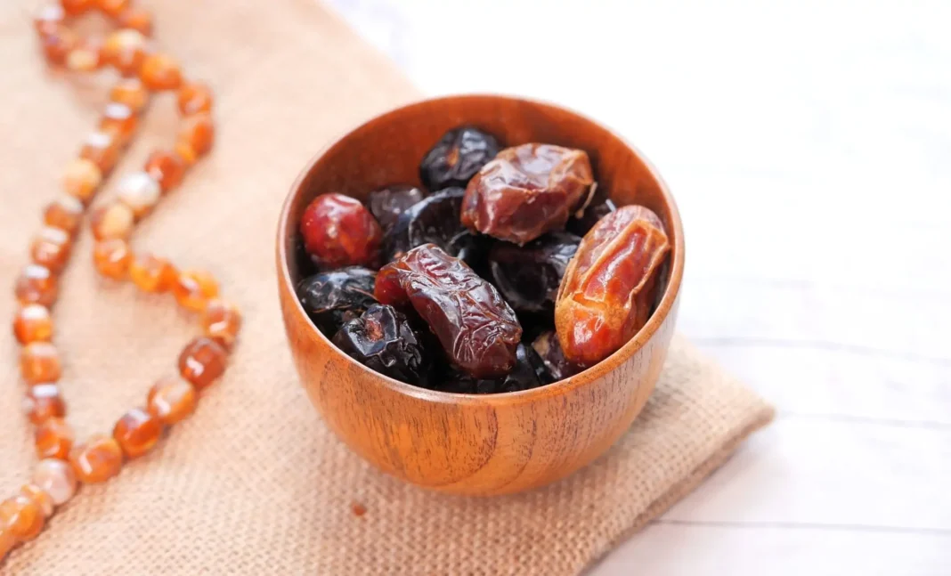 Calendrier du Ramadan 2024 en France : Les Horaires du Ftour (Iftar) à la Loupe Dattes fraîches dans un bol en bois pour le Ramadan 2024.