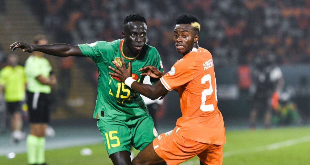 CAN 2023 : Le Sénégal accuse la CAF de Corruption, Imitant Djamel Belmadi Joueur sénégalais et néerlandais en duel lors d'un match de football.