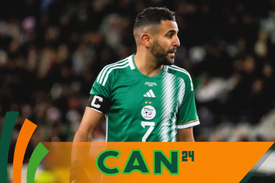 Joueur de football algérien portant maillot vert lors d'un match.