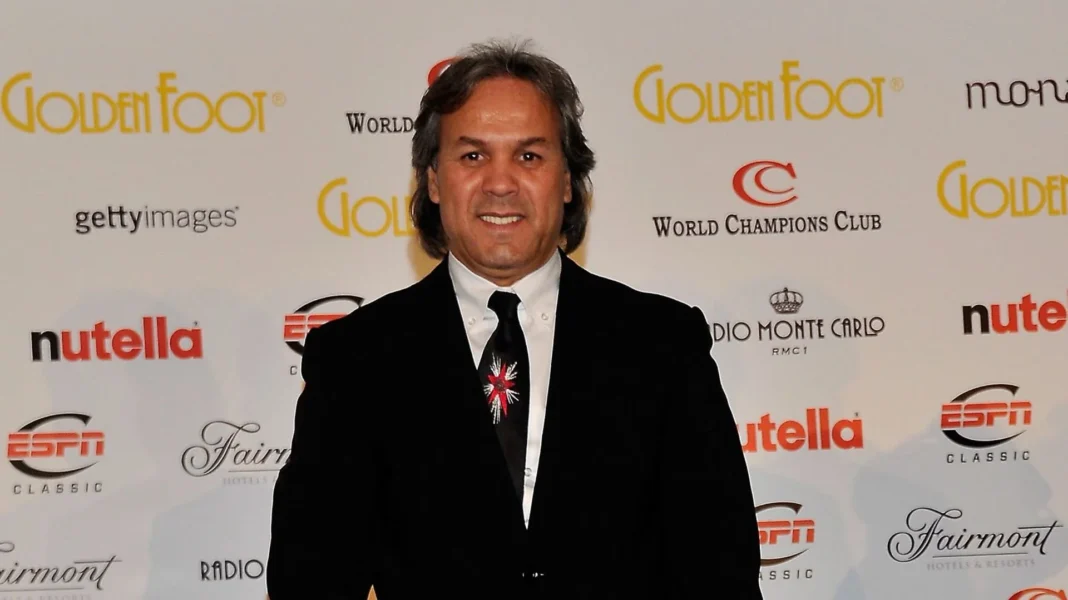 CAN 2023 : Rabah Madjer, le Ballon d’Or africain 1987 dévoile ses favoris Rabah Madjer lors d'une cérémonie, souriant, avec un fond de logos sportifs.