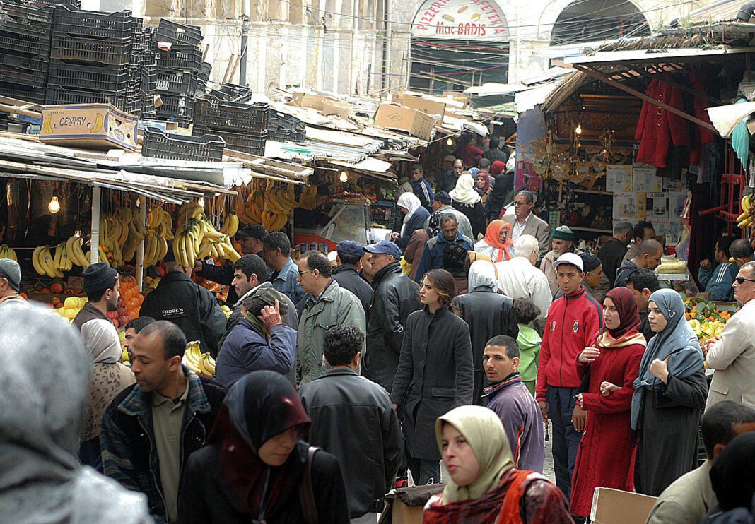Préoccupations économiques en Algérie : Seulement 27 % jugent la situation économique ‘bonne Foule dans un marché algérien avec vendeurs et acheteurs.