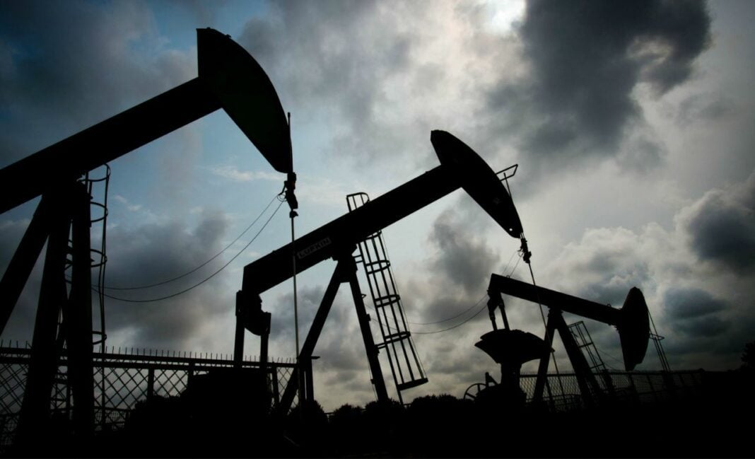 Impact contrasté de la baisse des cours du pétrole en Afrique : Gagnants et Perdants Pompes à pétrole en silhouette sous ciel nuageux en Afrique.