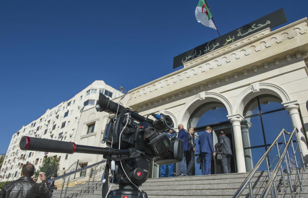 Scandale Judiciaire en Algérie : Les Services Secrets Qualifiés d’« Organisation Criminelle » par la Justice Caméra de presse devant un tribunal en Algérie, justice en cours.