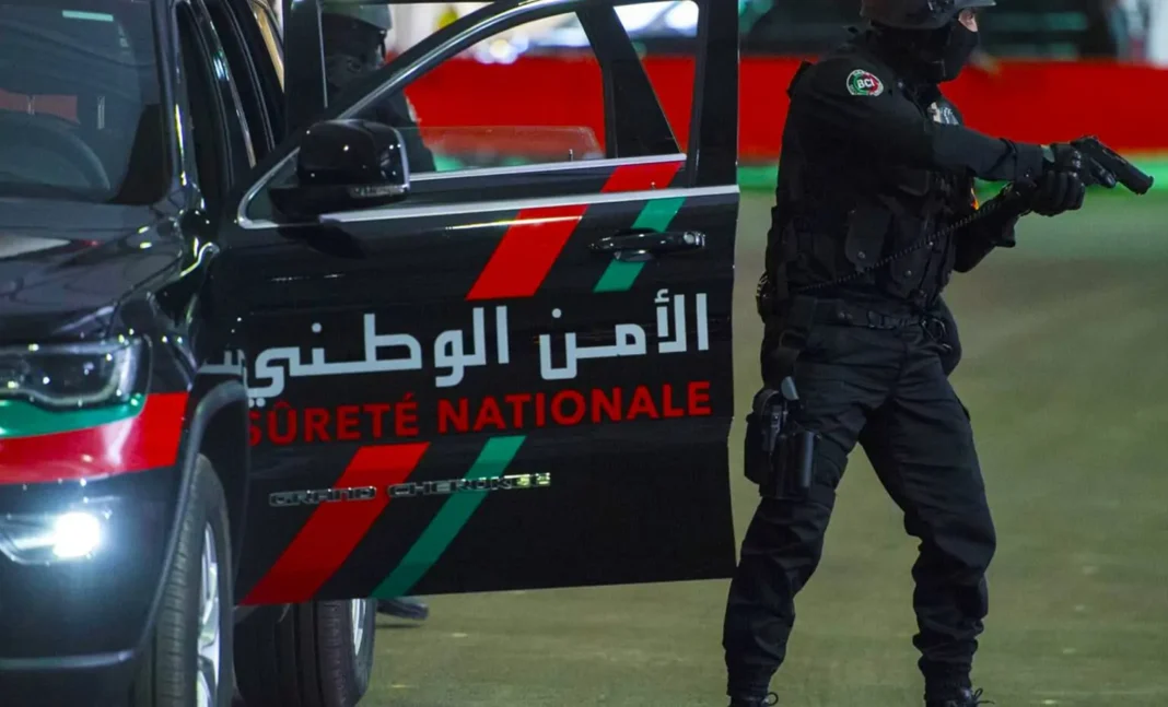 Agent de police armé près d'une voiture de la sécurité nationale algérienne.