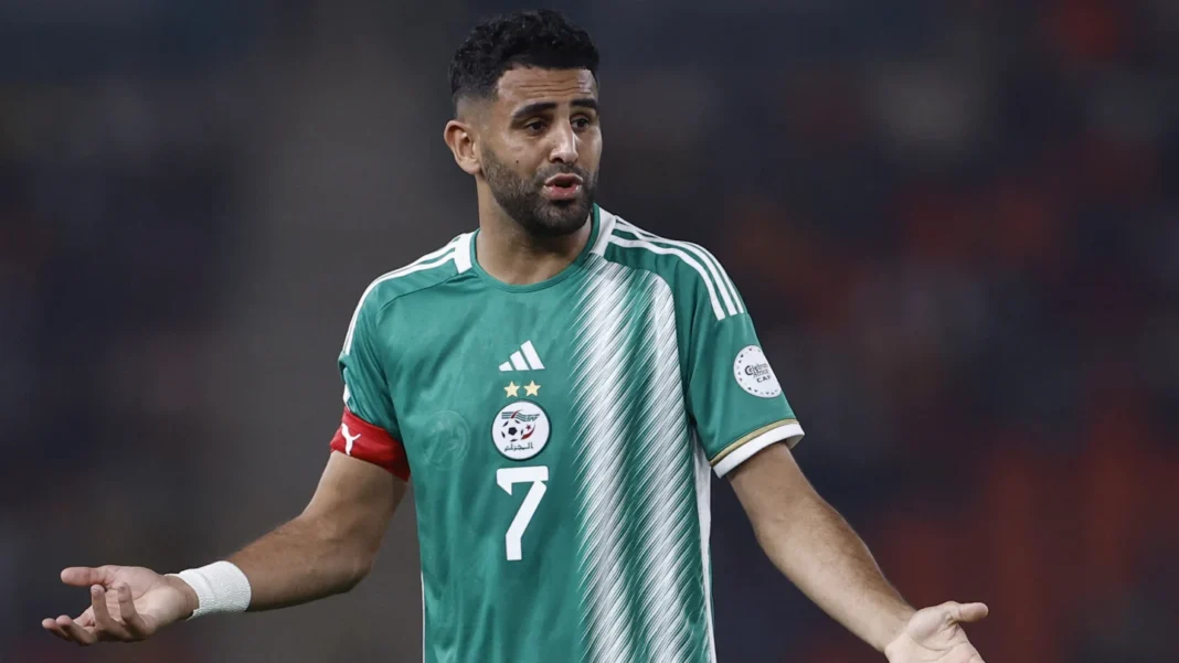 Riyad Mahrez portant le maillot de l'Algérie, en pleine action sur le terrain.