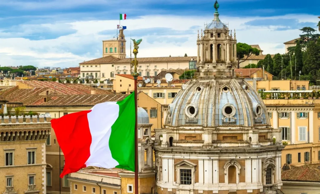 Italie : délivrance de 151’000 permis de travail pour les étrangers en vue pour 2024 Drapeau italien flottant avec vue sur Rome historique.