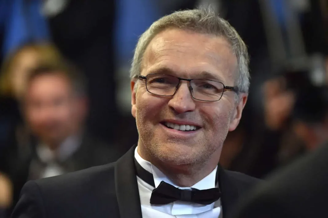 « Je rêve d’aller un jour en Algérie », Laurent Ruquier Laurent Ruquier souriant en costume lors d'un événement.