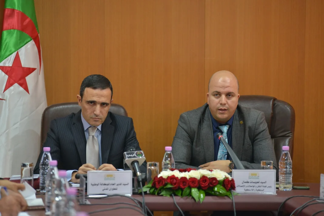 Nouveaux dirigeants d'Air Algérie Deux hommes lors d'une conférence officielle avec drapeau algérien en arrière-plan.