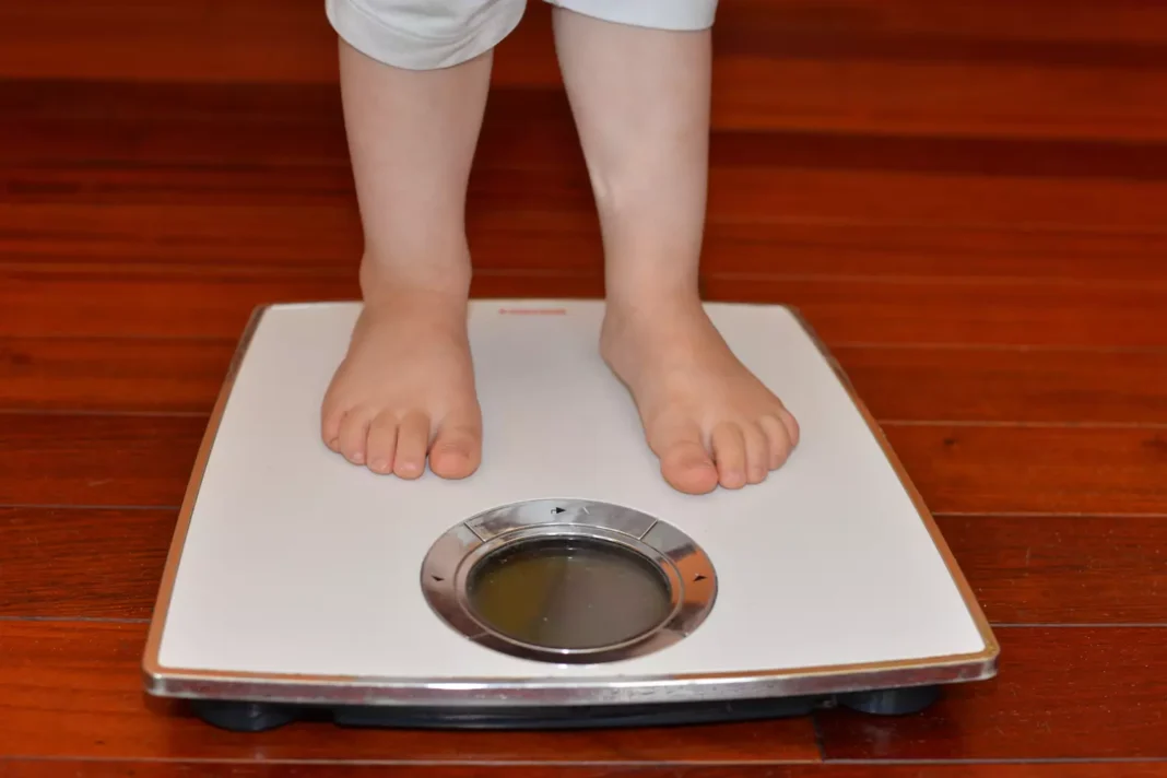 Poids d'un enfant sur une balance Enfant pesant sur une balance pour mesurer son poids.