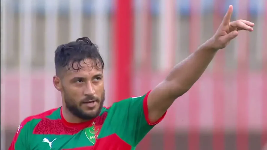 Youcef Belaïli en action, pointant du doigt lors d'un match de championnat.