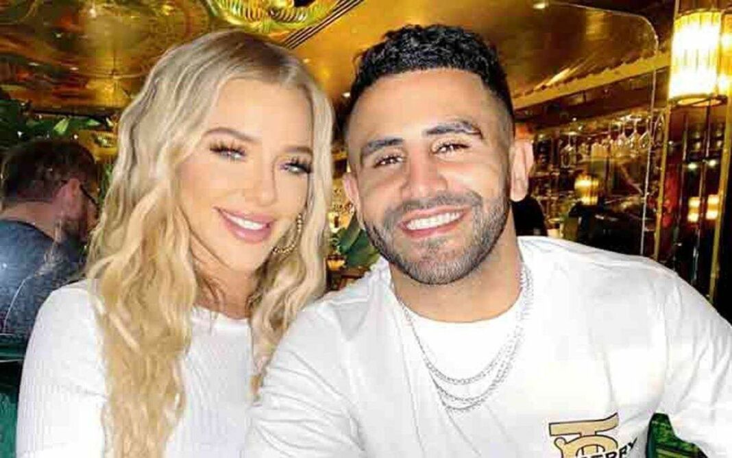 Riyad Mahrez et sa femme souriants lors d'une sortie.