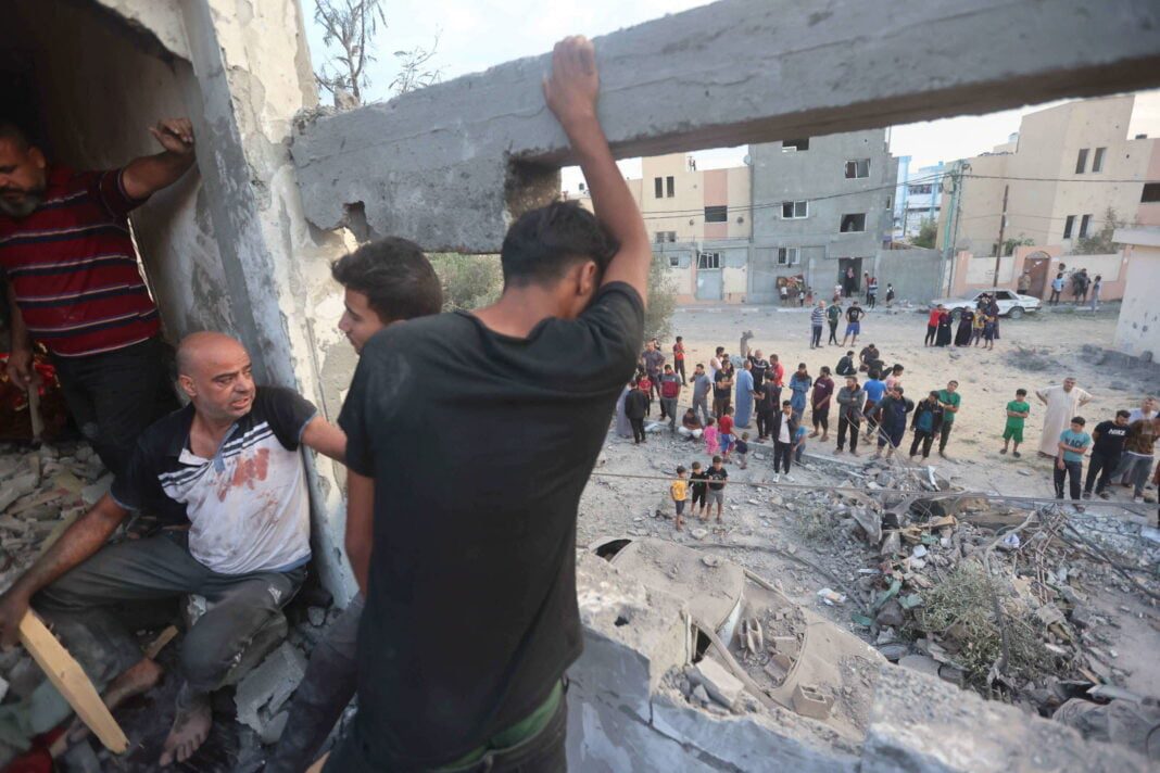 l’Union Africaine ferme ses portes à Israël suite à la guerre de Gaza Civils évacuant une zone de guerre à Gaza, destruction visible.