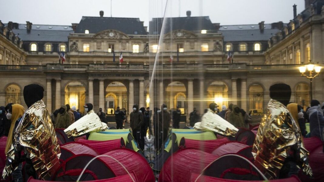 Guide pratique pour les sans-papiers souhaitant demander une autorisation de travail en France Fête populaire avec artistes et public devant l'Hôtel de Ville de Paris.