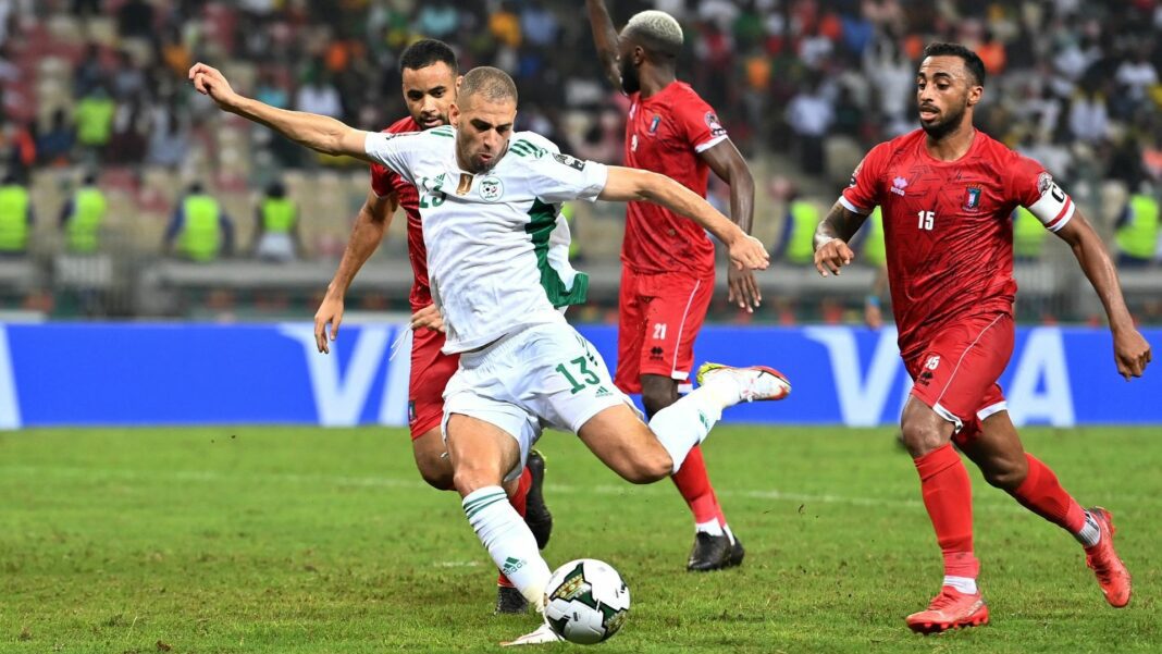 Islam Slimani sur le Point de Rejoindre l’Inter Milan ? Ses Révélations Chocs Joueur en blanc tentant de contrôler le ballon face à des adversaires en rouge.