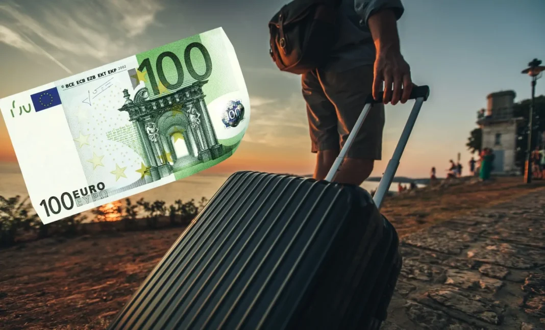 Voyageur avec valise et billet de 100 euros au coucher du soleil.