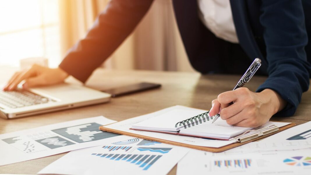 Réunion d'affaires avec documents financiers Personne en réunion d'affaires avec documents et ordinateur portable.