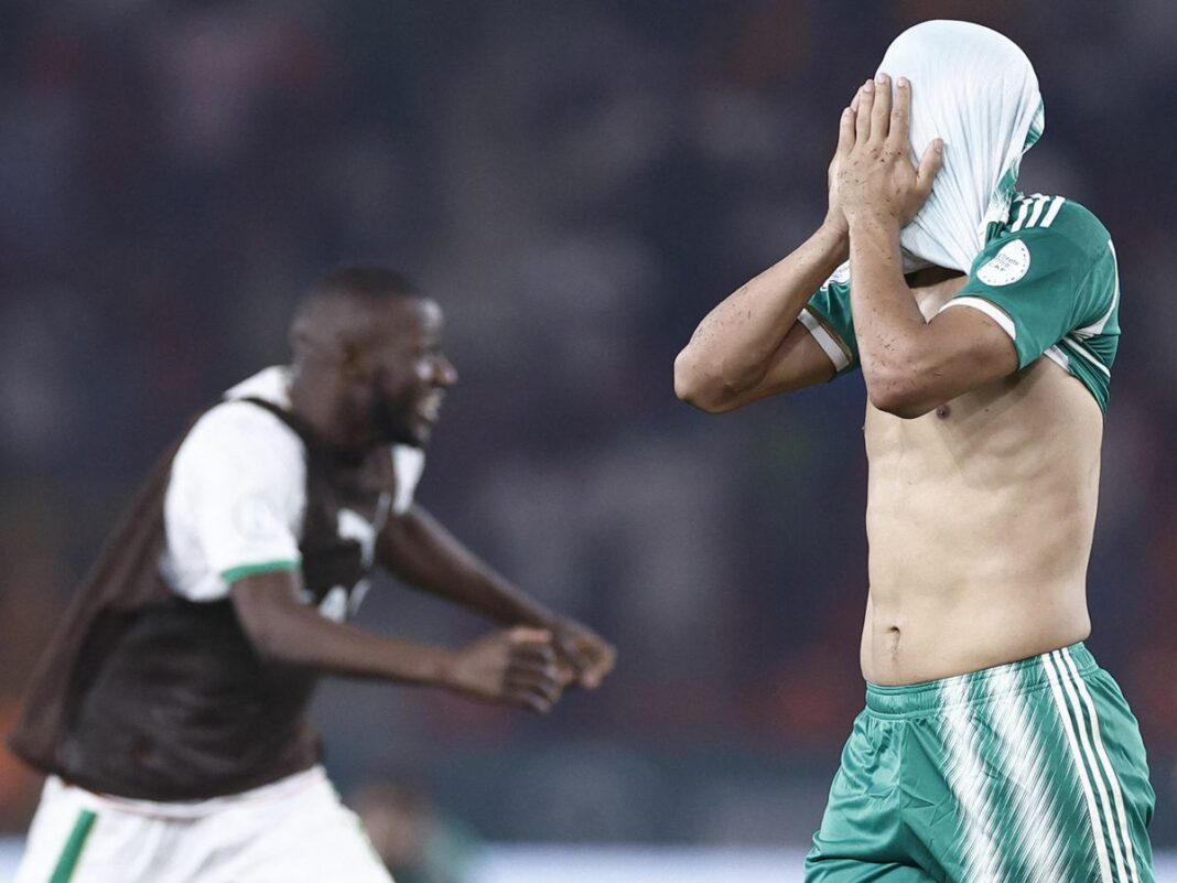 Riyad Mahrez cache son visage avec son maillot lors d'un match.