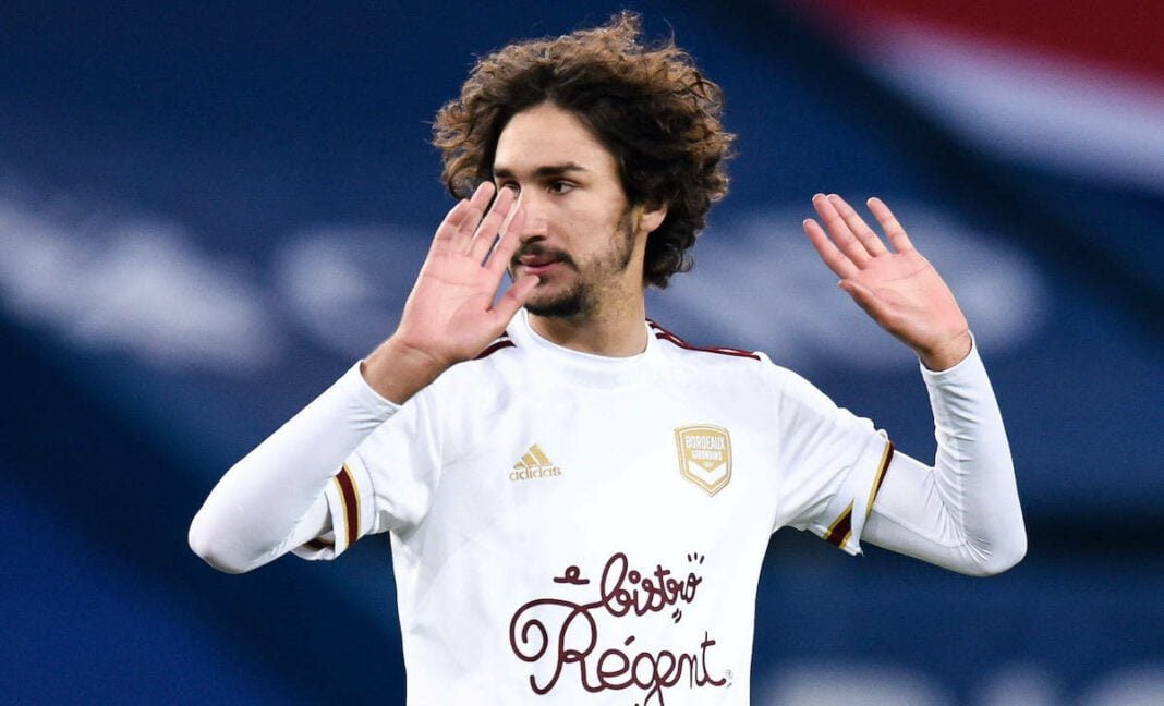 Yacine Adli en maillot blanc lors d'un match de football.