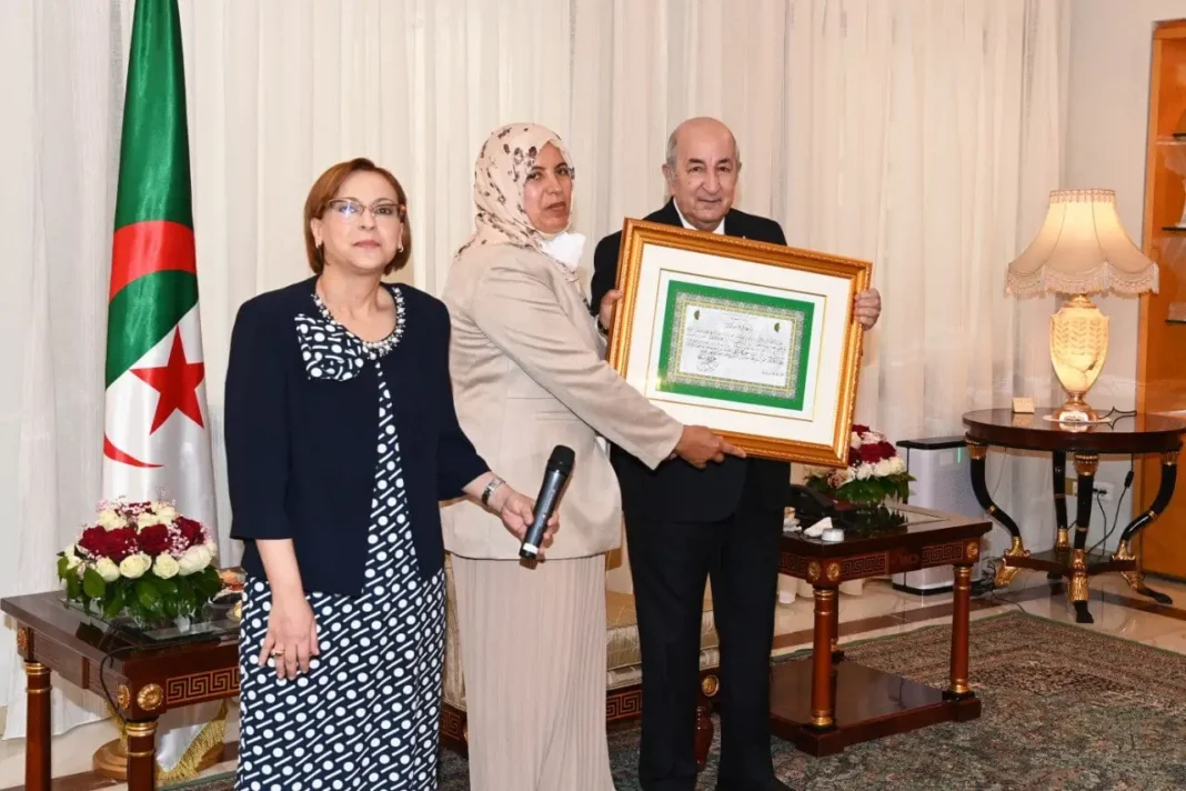 Femme algérienne recevant un prix lors d'une cérémonie officielle.