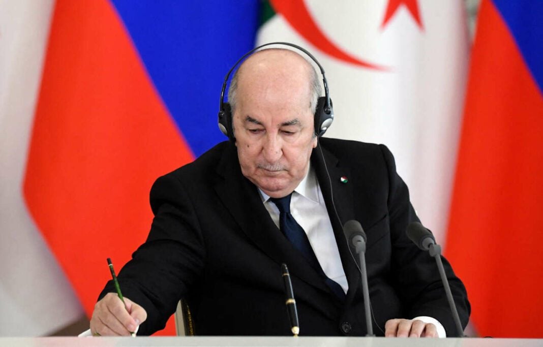 Algérie/Présidentielle anticipée : Le coup de poker de Tebboune qui divise l’opinion Tebboune lors d'une conférence avec drapeaux algérien et russe en arrière-plan.