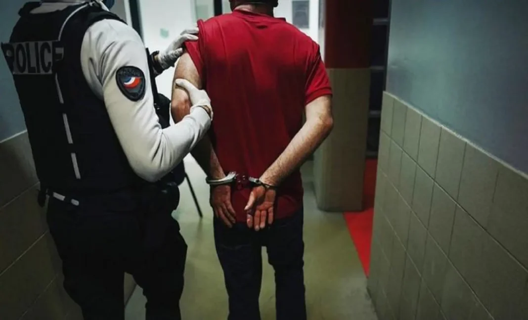 Policier arrêtant un homme avec des litres d'alcool en main.