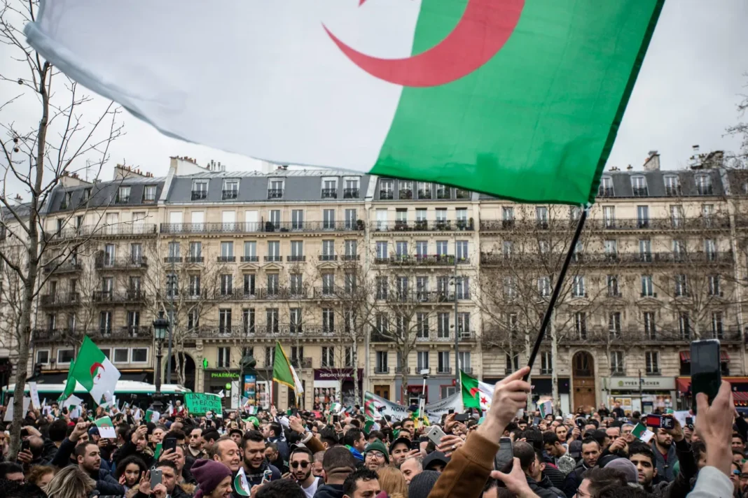 La diaspora algérienne ciblée par une attaque sans précédent Foule lors d'une manifestation avec drapeau algérien en France.