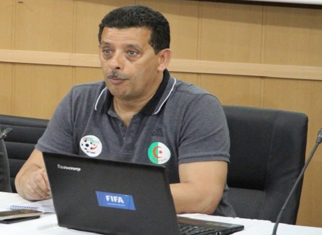 L’USM Alger boycottera-t-elle le match retour face au RS Berkane ? Taoufik Korichi en parle ! Taoufik Korichi en réunion, portant un polo gris avec logos FIFA et Algérie.