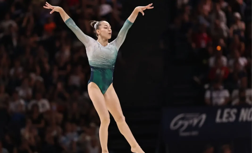 Découvrez les détails de cette vidéo sensationnelle sur Kaylia Nemour Gymnaste effectuant une figure lors d'une compétition de gymnastique.