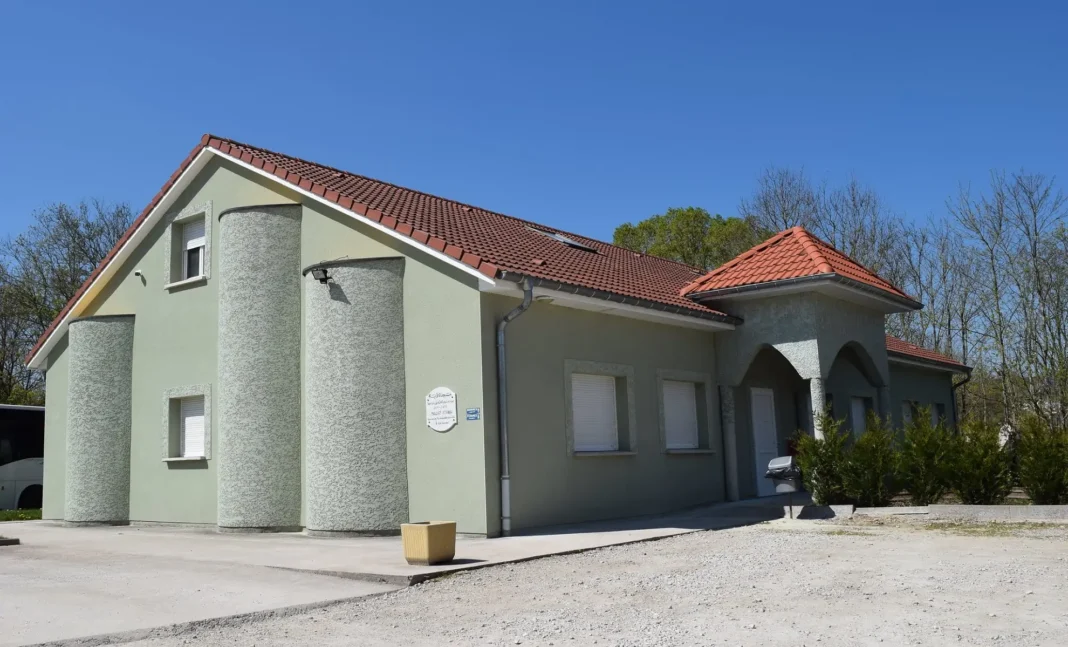 Profanation en plein Ramadan : Une tête de sanglier découverte devant une mosquée en France Maison moderne avec façade verte et toit en tuiles rouges.