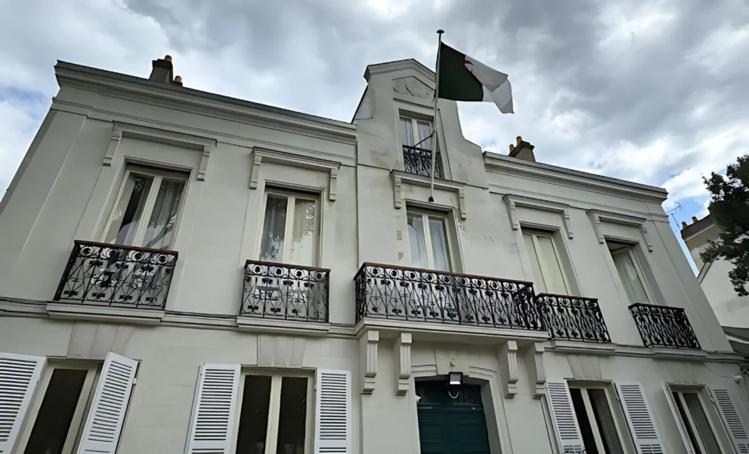 France-OQTF : quand la diaspora algérienne force la main à l’Hexagone Bâtiment blanc avec drapeau français en haut, ciel nuageux.