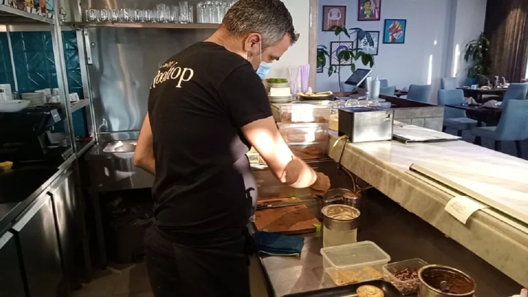 Chef Rabah Ourrad en cuisine Chef Rabah Ourrad préparant un plat dans un restaurant.