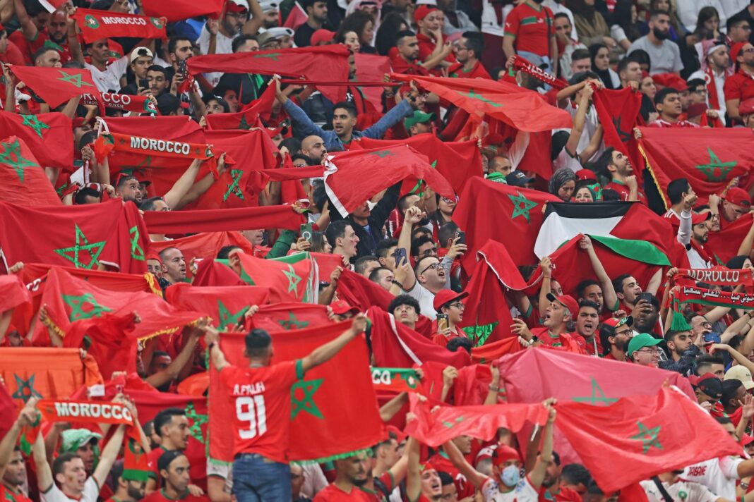 Supporters marocains avec drapeaux lors d'un match de football.