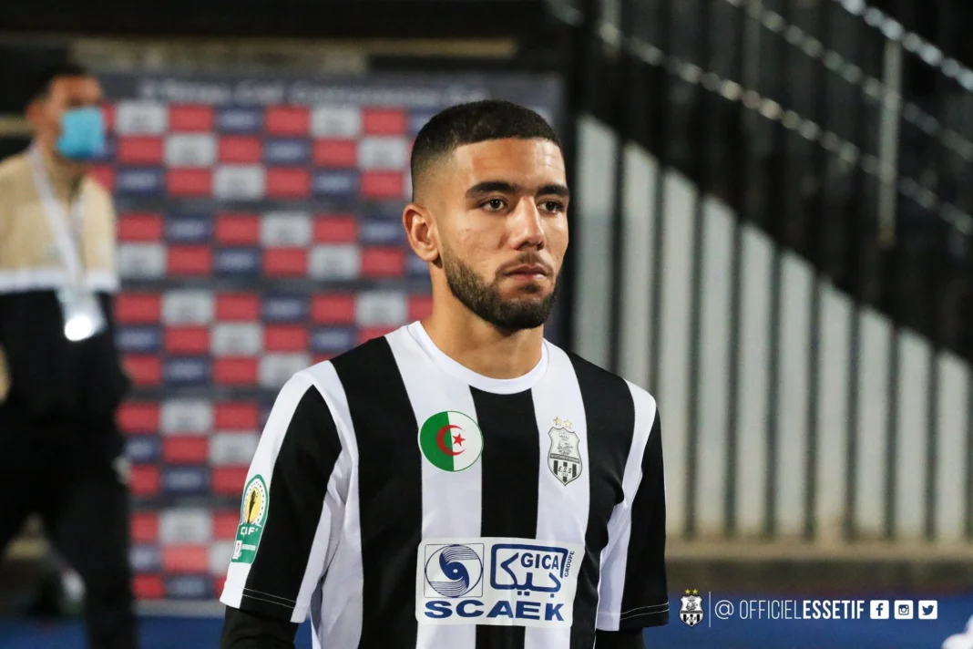 Ahmed Kendouci en action lors d'un match Ahmed Kendouci portant le maillot de l'équipe, concentré sur le jeu.