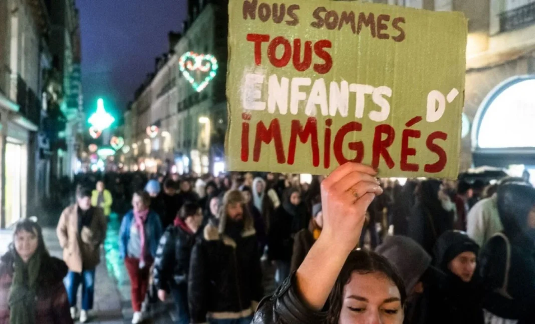 Manifestation dans la rue avec un panneau en faveur des immigrants.
