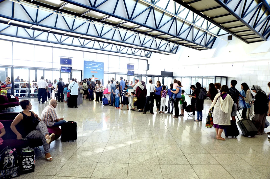 Passagers à l'aéroport d'Alger avec bagages et files d'attente.