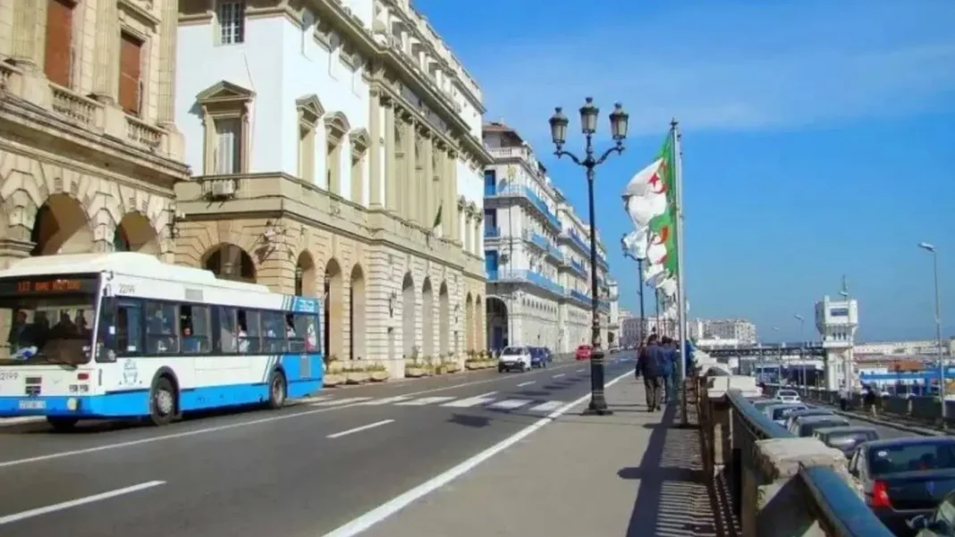 Vue du front de mer à Alger Promenade en bord de mer à Alger avec bus et bâtiments historiques.