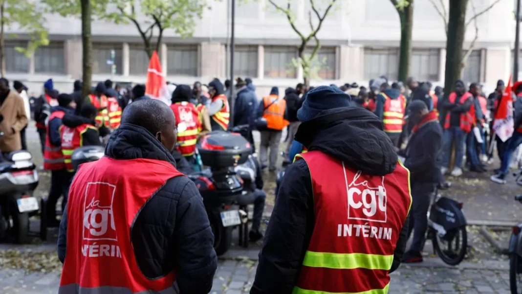 Manifestation avec des manifestants portant des gilets rouges et des drapeaux.