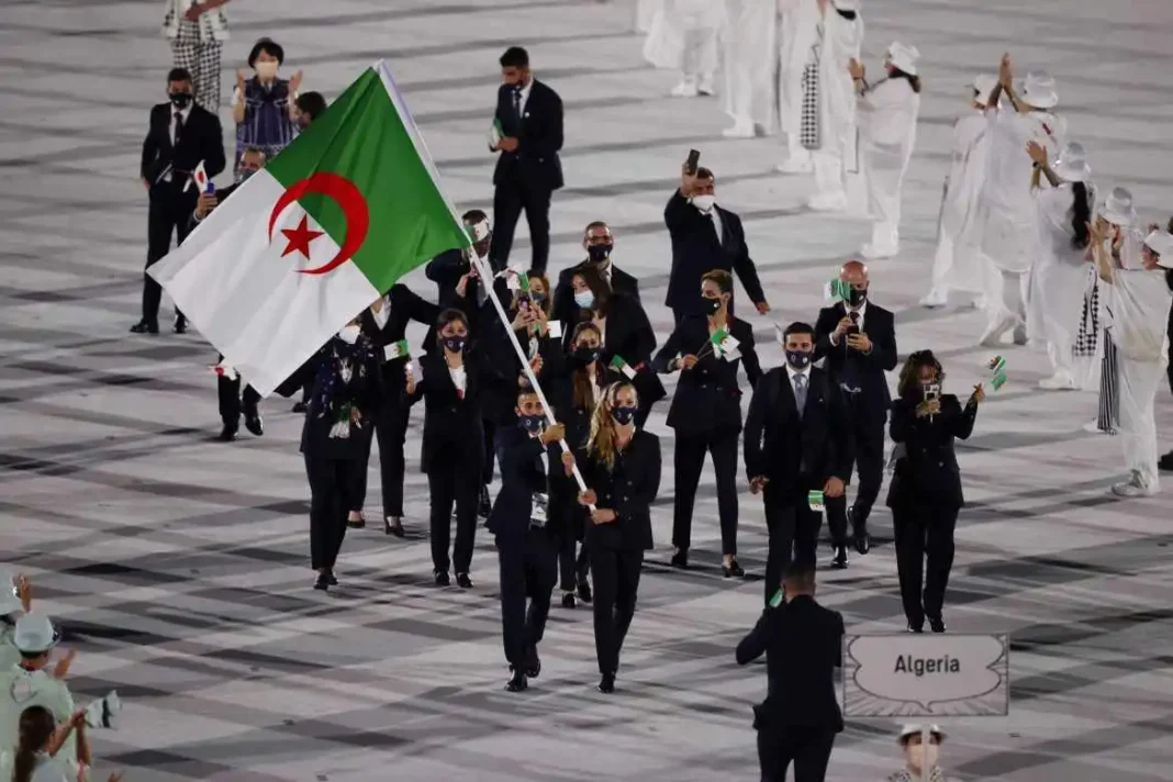 JO de Paris 2024 : L’Algérie, sensationnelle, sur le point de rafler une nouvelle médaille! Groupe d'athlètes algériens en tenue de cérémonie avec drapeau national.