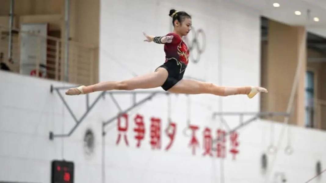 Duel Olympique : Kaylia Nemour face à Qiu Qiyuan pour l’or à Paris. Une concurrence rude, qui promet un spectacle épique… Jeune gymnaste en pleine performance lors d'une compétition.